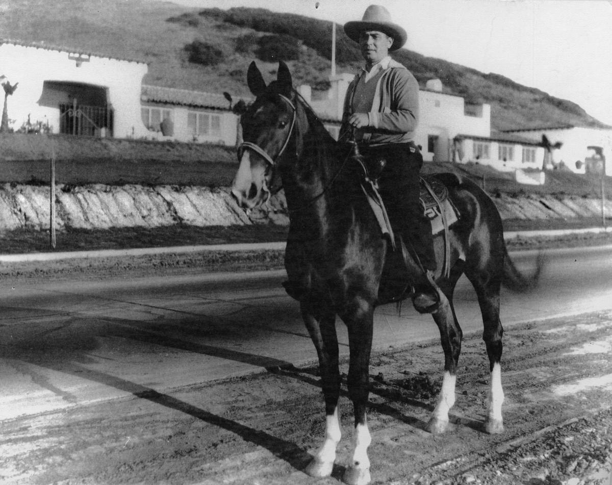 Horseback rider on El Camino Real in front of the Riding Academy